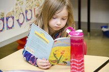 Girl staring at her book in her desk