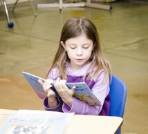 Girl reading a french textbook outloud